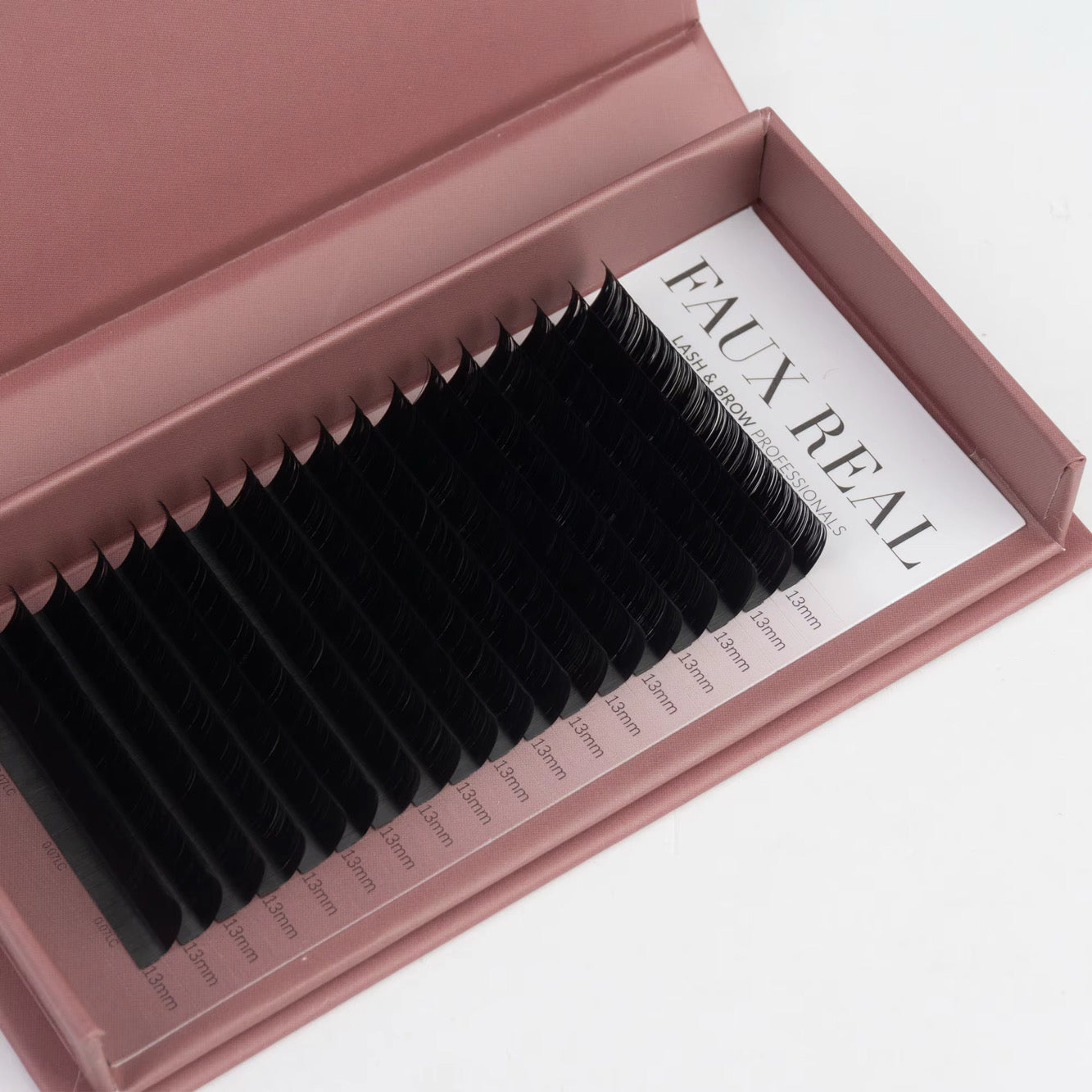 Set of false eyelashes in a pink case with 'Faux Real' branding.